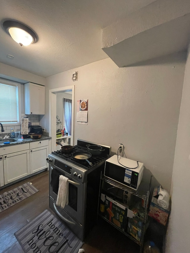 19307 Mansfield St, Detroit, MI 48235 - kitchen with stainless steel gas range, white cabinetry, a textured ceiling, dark countertops, and decorative backsplash