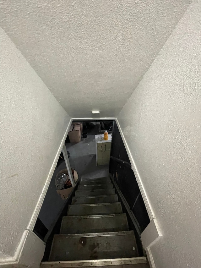 19307 Mansfield St, Detroit, MI 48235 - stairs featuring a textured wall, vaulted ceiling, and a textured ceiling