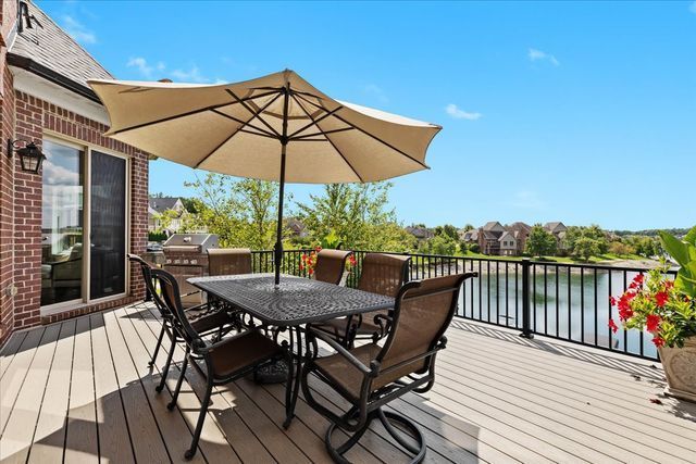 deck with a water view and area for grilling