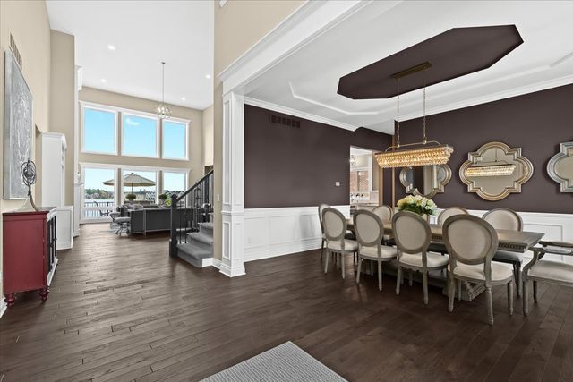 dining space with a notable chandelier, dark wood-type flooring, and ornamental molding