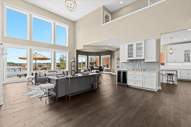 living room featuring wine cooler, a water view, dark hardwood / wood-style floors, and a chandelier