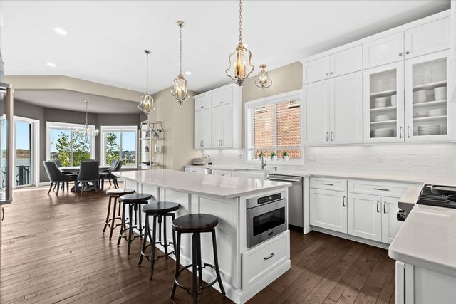 kitchen featuring decorative light fixtures, a center island, decorative backsplash, and white cabinets