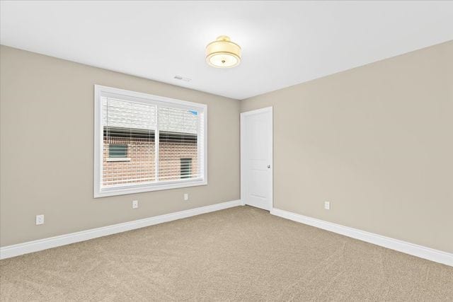 unfurnished room featuring light carpet