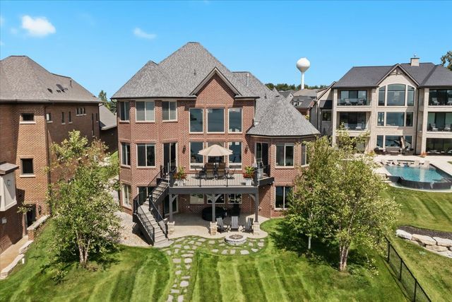 back of house featuring a pool side deck, a lawn, and a patio