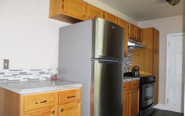 kitchen with tasteful backsplash, stainless steel fridge, and electric stove