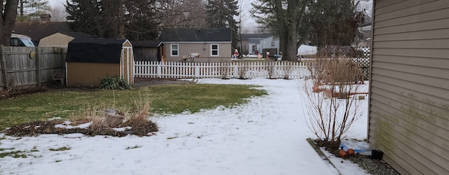 yard covered in snow with a storage shed