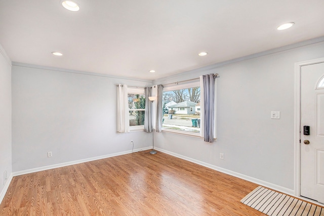 foyer entrance with ornamental molding and light wood-type flooring