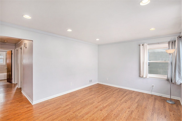 unfurnished room featuring crown molding, a healthy amount of sunlight, and light hardwood / wood-style floors