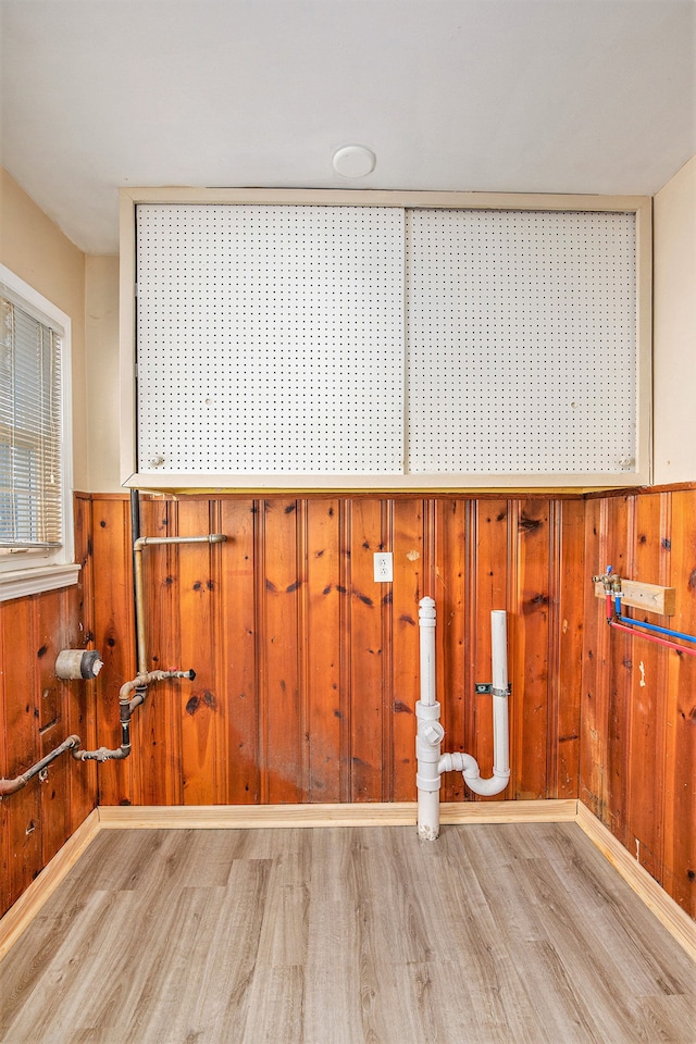 interior space featuring light wood-type flooring and wood walls