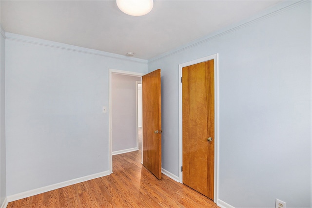 unfurnished room featuring ornamental molding and light hardwood / wood-style floors