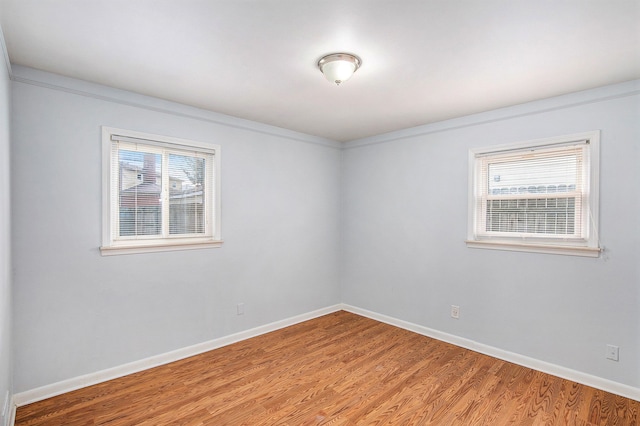 unfurnished room with wood-type flooring and a healthy amount of sunlight