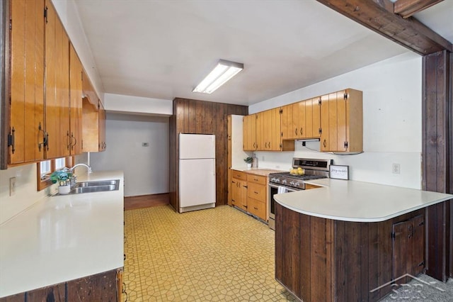 kitchen featuring white refrigerator, sink, kitchen peninsula, and stainless steel gas stove