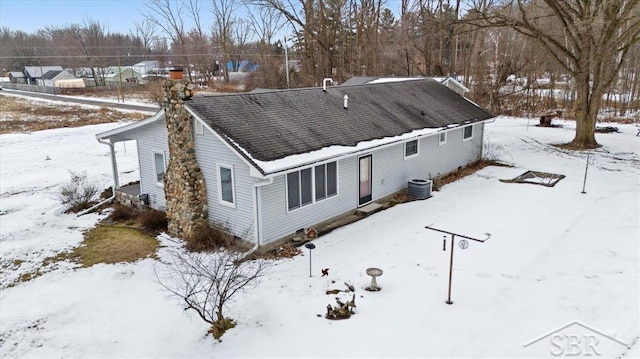 snow covered house featuring cooling unit