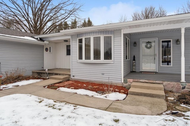 snow covered property entrance featuring a garage