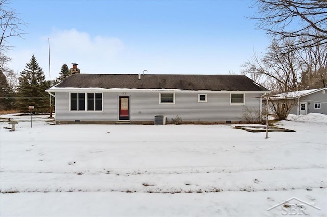 snow covered back of property with central AC