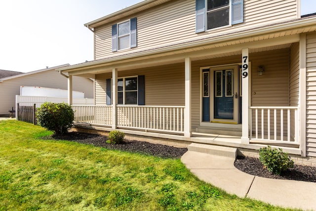 property entrance featuring a yard and covered porch