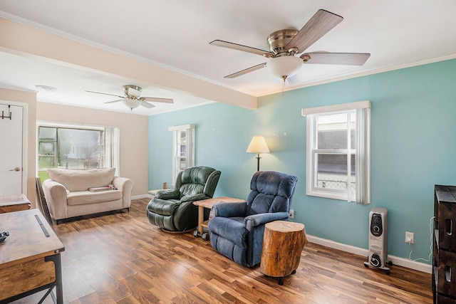 living room with hardwood / wood-style floors, crown molding, and ceiling fan