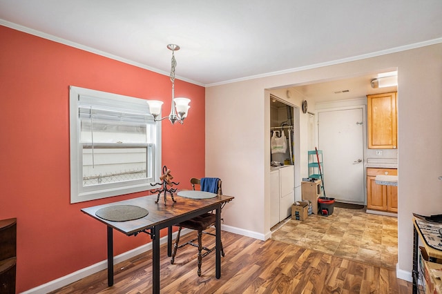 dining space with crown molding, a notable chandelier, and hardwood / wood-style flooring