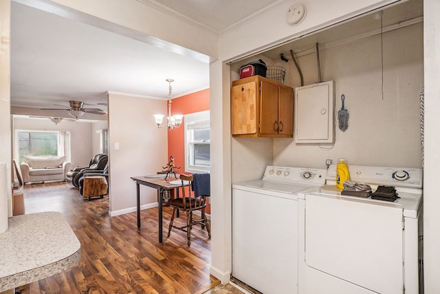 washroom featuring ceiling fan with notable chandelier, dark wood-type flooring, ornamental molding, and washer and dryer