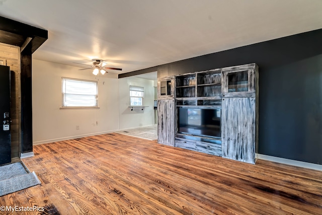 unfurnished living room featuring hardwood / wood-style flooring and ceiling fan