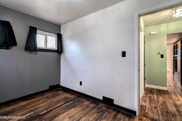 spare room featuring dark wood-type flooring