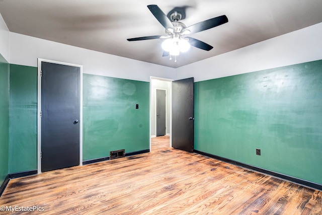 unfurnished bedroom with ceiling fan, a closet, and light hardwood / wood-style flooring