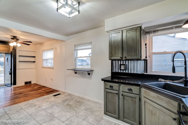 kitchen with ceiling fan, sink, and light hardwood / wood-style flooring