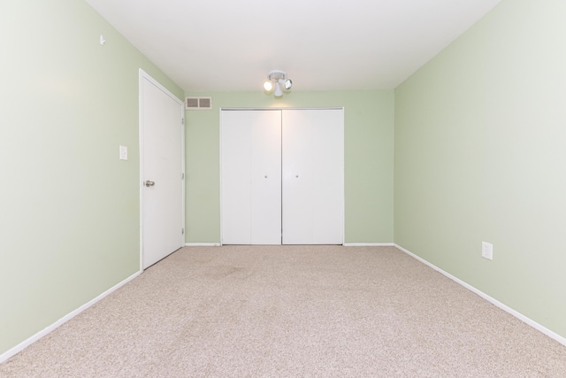 unfurnished bedroom featuring carpet flooring and a closet