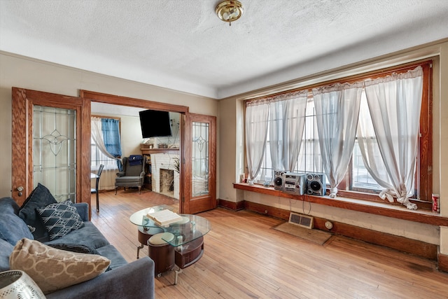 living room with a textured ceiling and light wood-type flooring