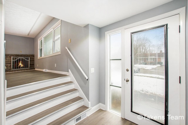 entryway featuring hardwood / wood-style flooring and a fireplace