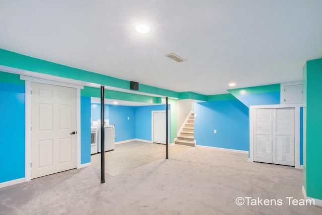 basement with washer and clothes dryer and light colored carpet