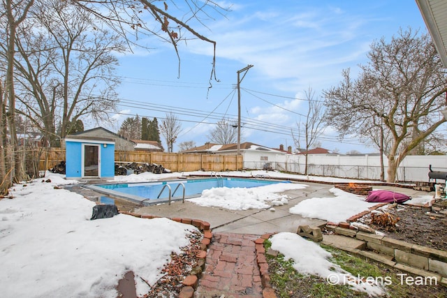 snow covered pool featuring a storage shed