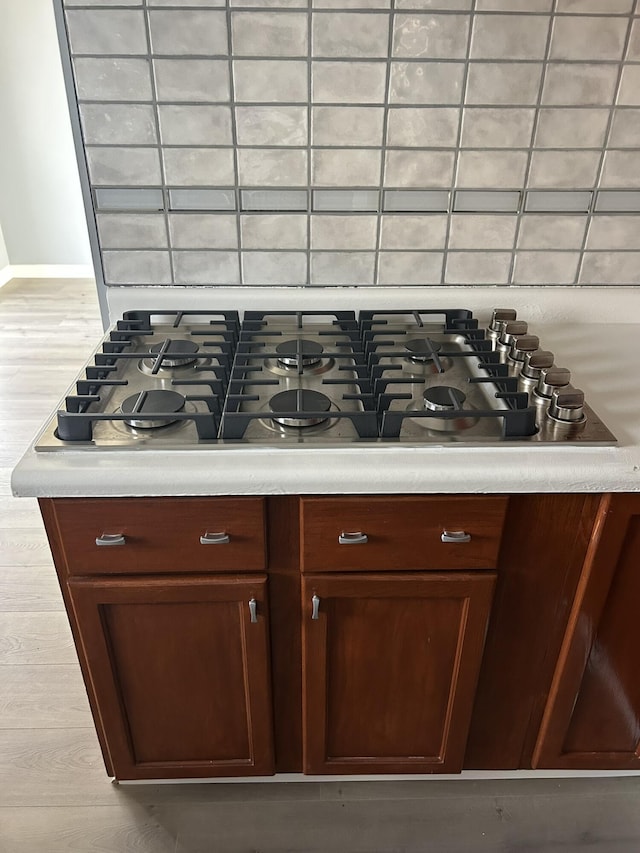 2200 Rossiter Pl, Lansing, MI 48911 - kitchen view of stainless steel gas cooktop, light countertops, baseboards, and light wood finished floors
