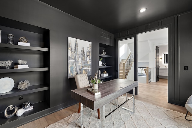 office featuring built in shelves and light wood-type flooring