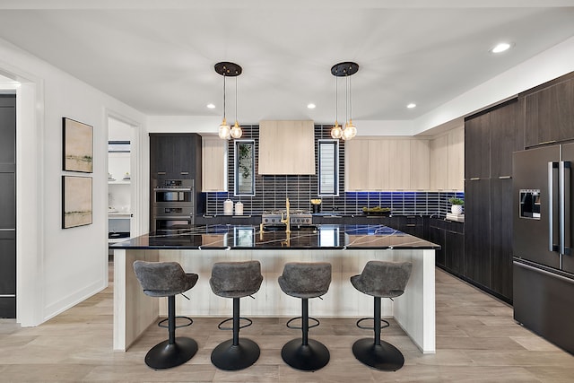 kitchen with pendant lighting, stainless steel appliances, a kitchen breakfast bar, and a kitchen island with sink