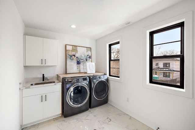 laundry room featuring cabinets, washer and dryer, and sink