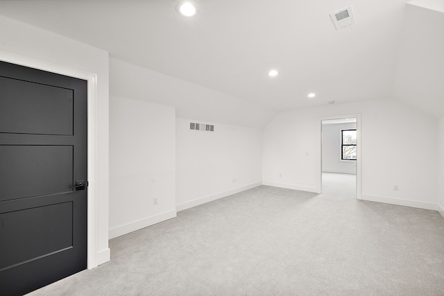 bonus room featuring lofted ceiling and light colored carpet