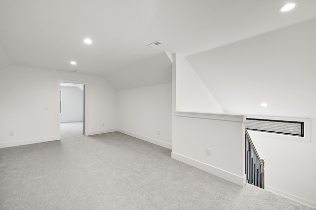 additional living space with light colored carpet and lofted ceiling