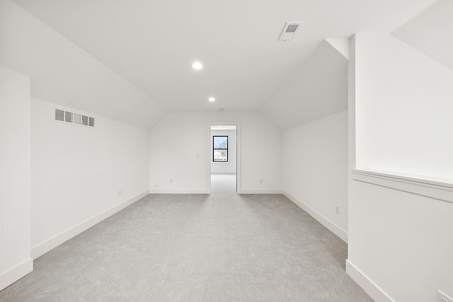 bonus room featuring vaulted ceiling and light colored carpet