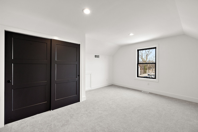 additional living space with vaulted ceiling and light colored carpet