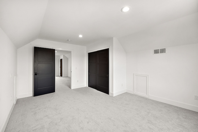 bonus room featuring lofted ceiling and light carpet