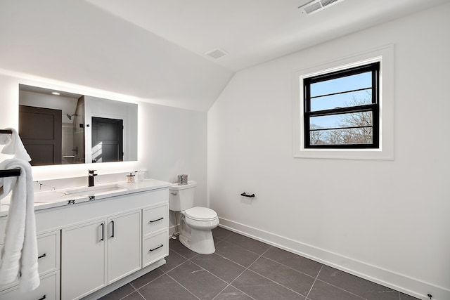 bathroom featuring tile patterned flooring, vanity, vaulted ceiling, toilet, and walk in shower