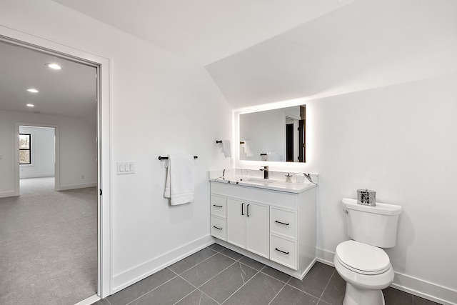 bathroom with vanity, vaulted ceiling, and toilet