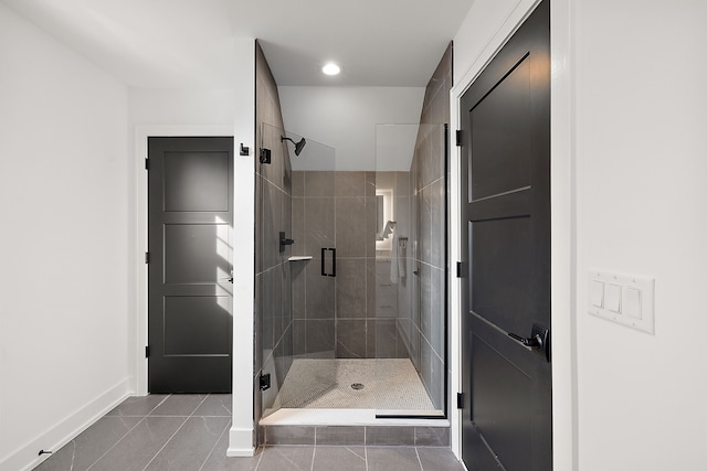 bathroom with a shower with shower door and tile patterned flooring