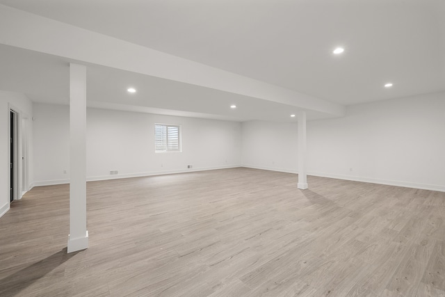 basement with light hardwood / wood-style flooring