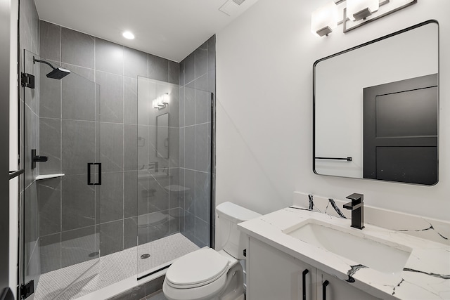 bathroom featuring vanity, toilet, and a shower with door