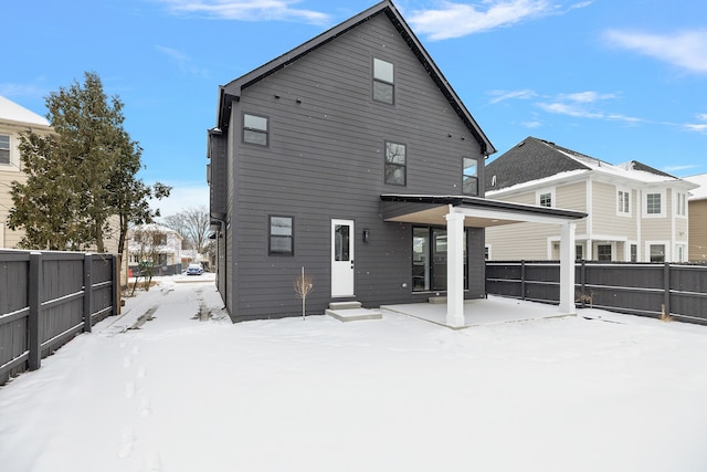 view of snow covered back of property