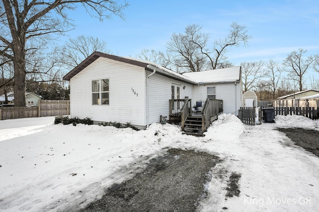 snow covered rear of property with a wooden deck