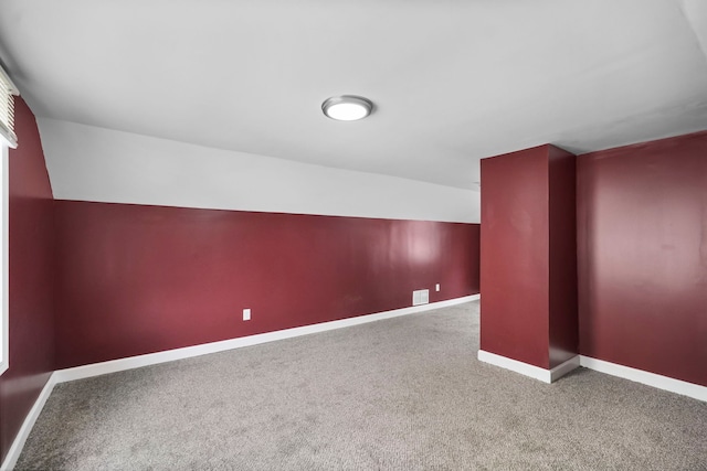 bonus room featuring vaulted ceiling and carpet