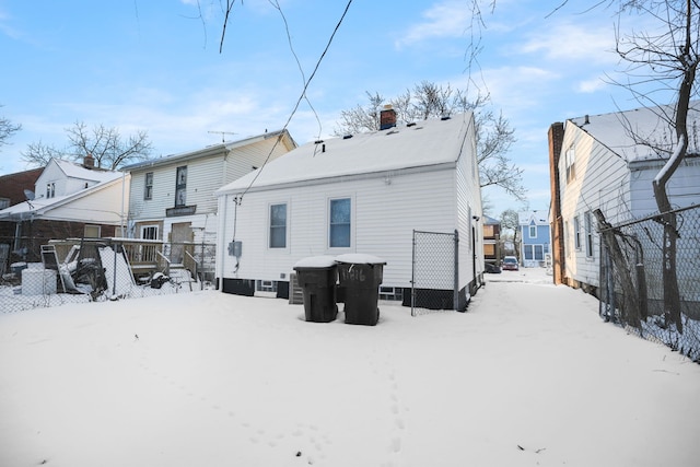 view of snow covered rear of property